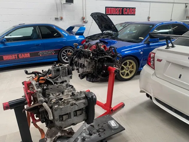 A couple of cars that are in a garage.