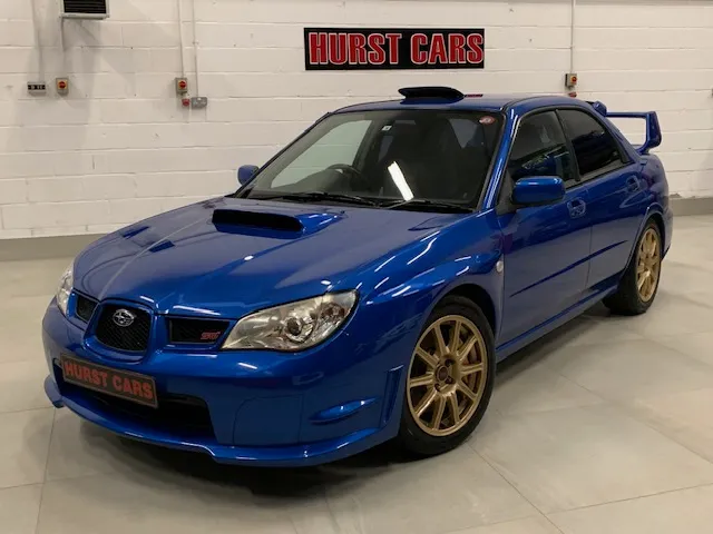 A blue subarunt is parked in a garage.