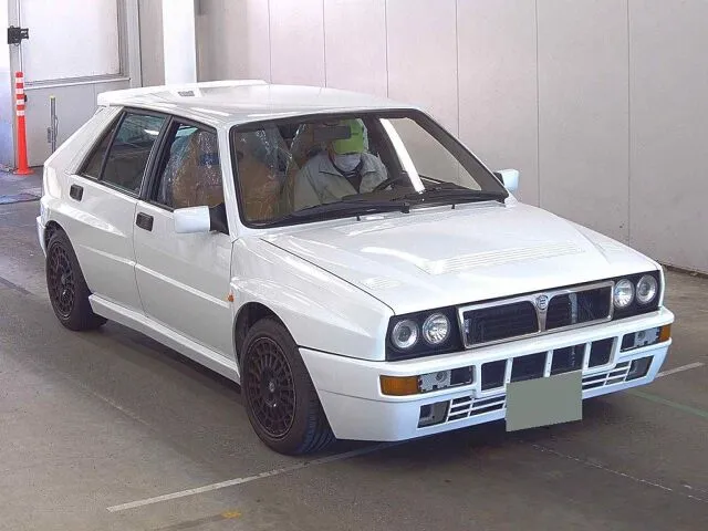 A white car is parked in a garage.